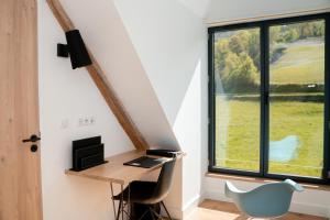 Ayros-ArbouixLodge du Hautacam的客房设有书桌和窗户。