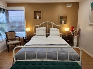 弗兰克斯顿Home in Frankston的一间卧室配有带白色床单和枕头的金属床。