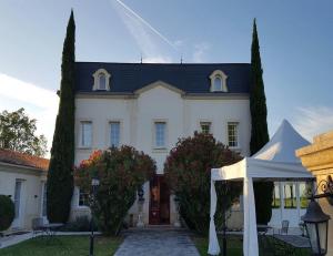 马尔戈Hôtel de Margaux的白色的房子,前面有帐篷