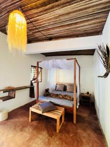 AmbaroNatShi Lodge的一间卧室配有天蓬床和长凳