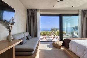 泽尔韦尼翁​Le Grand Bleu Resort的一间卧室配有一张床、一张沙发和一个大窗户