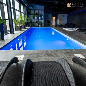 比亚韦斯托克皇家酒店及Spa的一座带椅子的大型蓝色游泳池