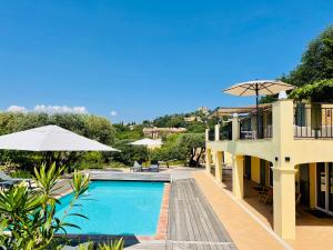 格里莫Villa Leopard Grimaud的享有带遮阳伞的度假村游泳池的景致