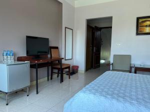 海阳Khách Sạn Sông Lô的一间卧室配有一张床和一张书桌及电视