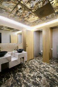 奥斯陆Super Stay Hotel, Oslo的一间带两个盥洗盆的浴室和天花板上的一幅画