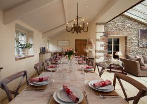 霍尼顿Hutchinghayes Farmhouse的一间用餐室,配有长桌子、椅子和女人