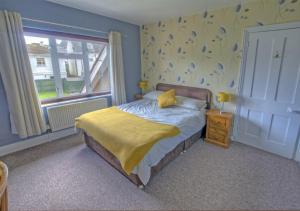 锡顿Dalmose的一间卧室配有一张黄色毯子床