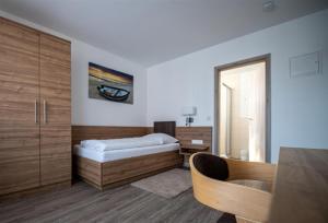 菲尔恩海姆Hotel Post Viernheim UG的一间卧室配有一张床、一张书桌和一面镜子
