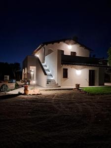 蒙特法尔科L'Antico Fienile的白色的房子,晚上有楼梯和灯