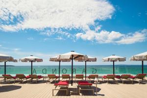 帕尔马海滩加伦达纯盐酒店 - 仅限成人的海滩上的一组椅子和遮阳伞