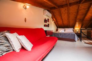 耶拉基尼Delmare Olive beach house II的客厅配有红色的沙发和床。
