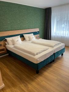 海姆巴赫Art Hotel Eifel的卧室设有两张床铺和绿色的墙壁