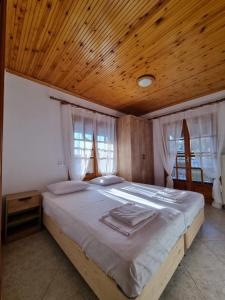VergiaOASIS BEACH HOUSE的一间卧室设有一张带木制天花板的大床