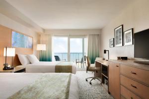 弗吉尼亚海滩Surfbreak Virginia Beach Oceanfront, Ascend Hotel Collection的酒店客房设有两张床和电视。