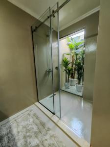 迪拜Villa 29 Suite A - Home Vacation的玻璃淋浴间,浴室内装有植物