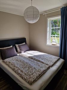 雪平斯维克Strandgarden的卧室内的一张大床,设有窗户