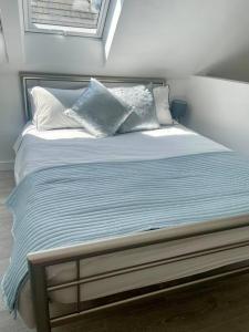 滨海巴顿Cosy accommodation, easy walk to beach!的一张带蓝色和白色枕头的床