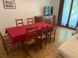 JaujacNOUVEAU Maison de la place的一间用餐室,配有红色的桌子和椅子