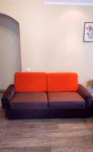 第聂伯罗2кімнатні апартаменти район Даффі的坐在房间里一张橙色和棕色的沙发