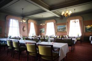 埃克舍厄克西城镇酒店的用餐室设有桌椅和窗户。