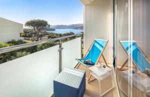 杜布罗夫尼克Club Dubrovnik Sunny Hotel的阳台配有椅子,享有海景。