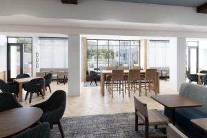 温特黑文Staybridge Suites Winter Haven - Auburndale的用餐室设有桌椅和窗户。