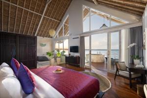 珀尼达岛Pramana Natura Nusa Penida的一间带大床的卧室和一间客厅