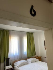 科济纳PENZION FARAON - CASINO ALFASTREET的一间卧室设有床铺和一个带绿色窗帘的窗户。