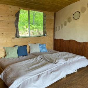 ShimatokkariTezukuri Cottage Mauranarani - Vacation STAY 49824v的小木屋内的一张大床,设有窗户