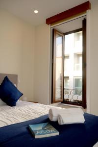 埃斯平霍Cabo do Mar Apart- Azul Beach的一间卧室配有带毛巾的床和窗户。