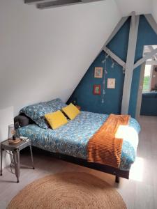 Hesdigneul-lès-BoulogneLe grenier de Mamou的一间卧室配有一张蓝色墙壁的床
