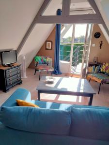 Hesdigneul-lès-BoulogneLe grenier de Mamou的客厅配有蓝色的沙发和桌子
