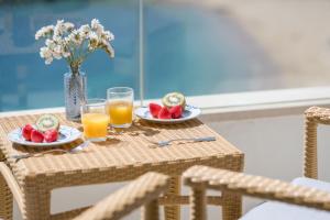 圣安东尼奥·德·卡隆罗萨马尔酒店的一张桌子,上面放两盘水果和橙汁