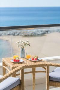 圣安东尼奥·德·卡隆罗萨马尔酒店的一张桌子,上面放两盘水果和橙汁