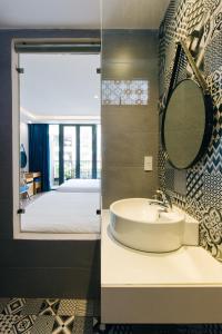 岘港La Maison De Fleurs的一间带水槽和床的浴室