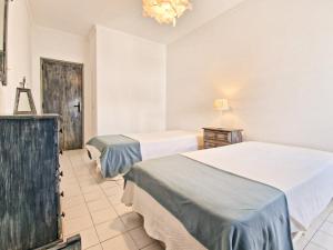 阿尔布费拉Jcmar Apartments - 100 m from the beach - free wifi - by bedzy的酒店客房设有两张床和吊灯。