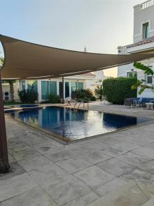 迪拜Villa 29 Suite A - Home Vacation的庭院内一个带遮阳伞的游泳池