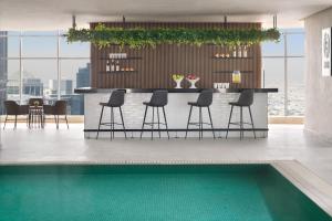 多哈Element by Westin West Bay Doha的厨房设有配备椅子的酒吧和游泳池