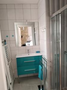 拉康提内勒La Flottille, La Cotinière的浴室设有蓝色水槽和镜子