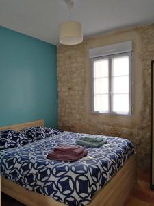 拉康提内勒La Flottille, La Cotinière的一间卧室设有一张床和一个窗口