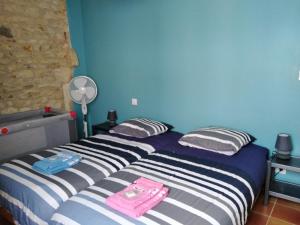 拉康提内勒La Flottille, La Cotinière的一间卧室设有两张床和蓝色的墙壁