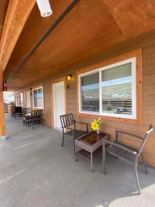 加德纳Rhodopa Lodge at Yellowstone的门廊配有椅子和桌子,设有窗户