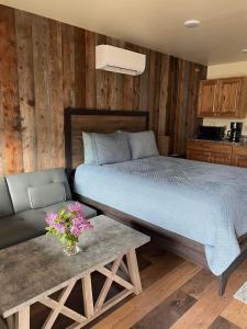 加德纳Rhodopa Lodge at Yellowstone的一间卧室配有一张床、一张沙发和一张桌子