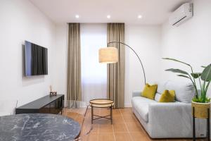 那不勒斯Aroma Apartment, Maschio Angioino-Porto Di Napoli的客厅配有沙发和桌子