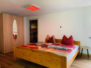 SaupsdorfNaturhof Kluge的一间卧室配有一张带红色枕头的大型木制床。