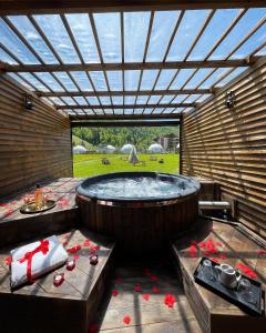 阿祖加Hotel Pin Azuga的一个带桌子的庭院里的大型热水浴缸