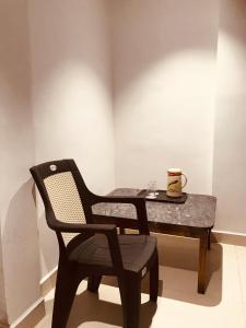 比拉斯布尔Prestige Guest House & Hostel的黑椅子和桌子,上面有杯子