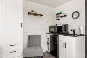 弗雷德里克斯堡New Wilderness Hideout-Cozy Container Home的厨房配有黑色冰箱和椅子