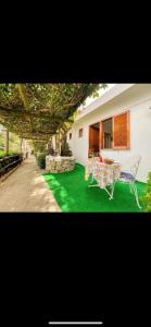 伊斯基亚Guesthouse Coralba的一座带桌椅的绿色庭院