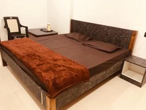 比拉斯布尔Prestige Guest House & Hostel的一张大床,位于带椅子的房间里